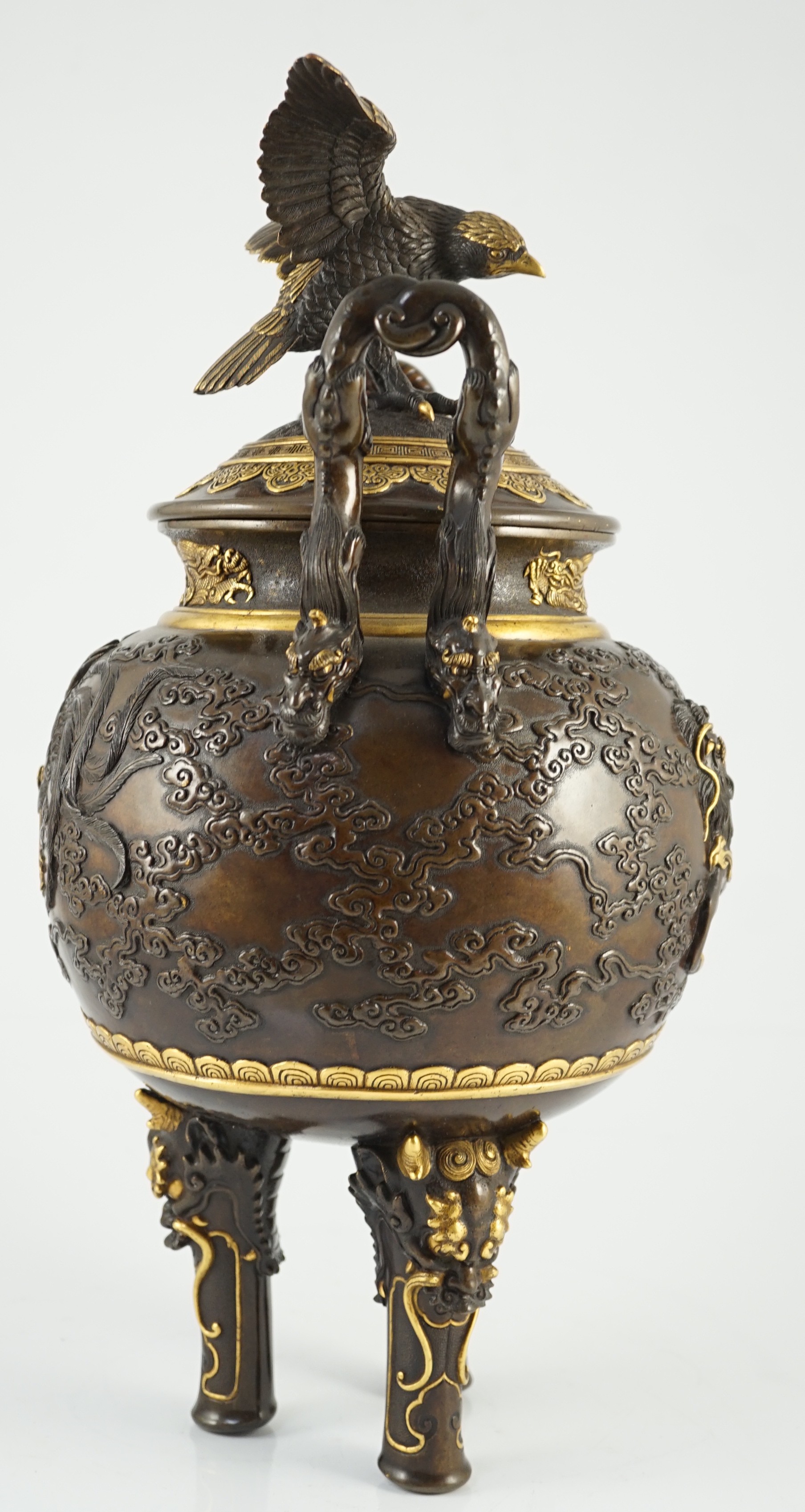 An impressive Japanese brown patinated and gilded bronze tripod koro and cover, by Miyao Eisuke, Meiji period, 42cm high, 23cm wide